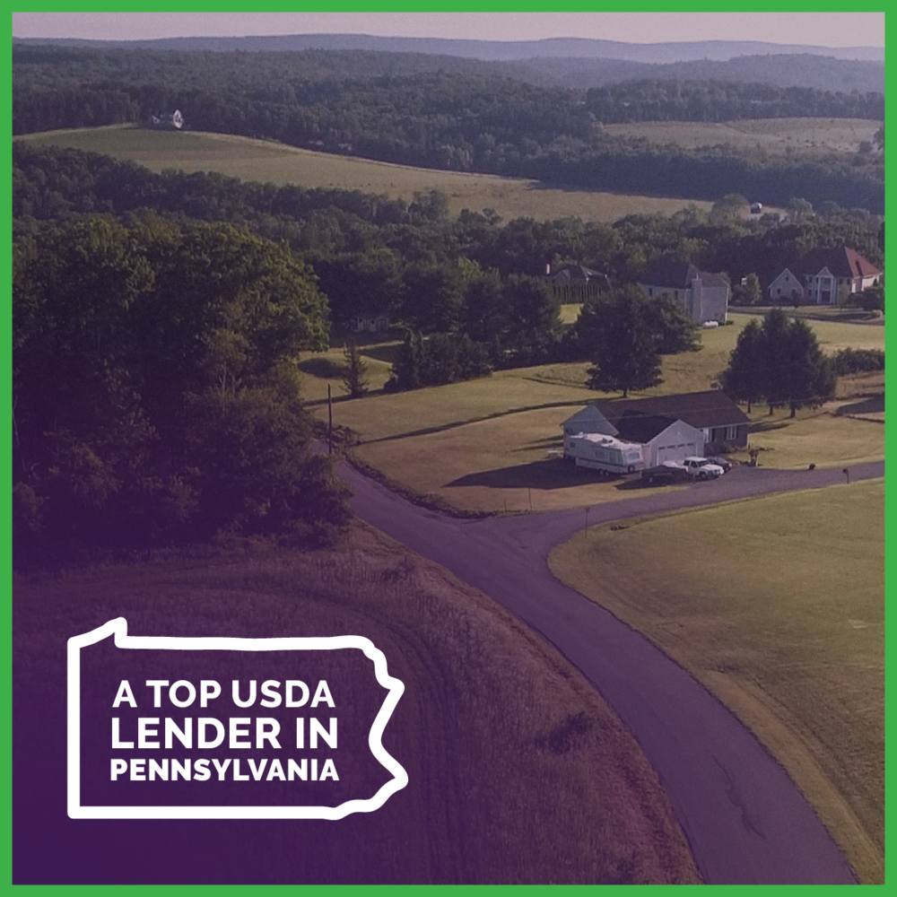Countryside featuring rolling green hills and a white home along a paved roadway with a state logo of Pennsylvania with fine print stating: "A Top USDA Lender in Pennsylvania."
